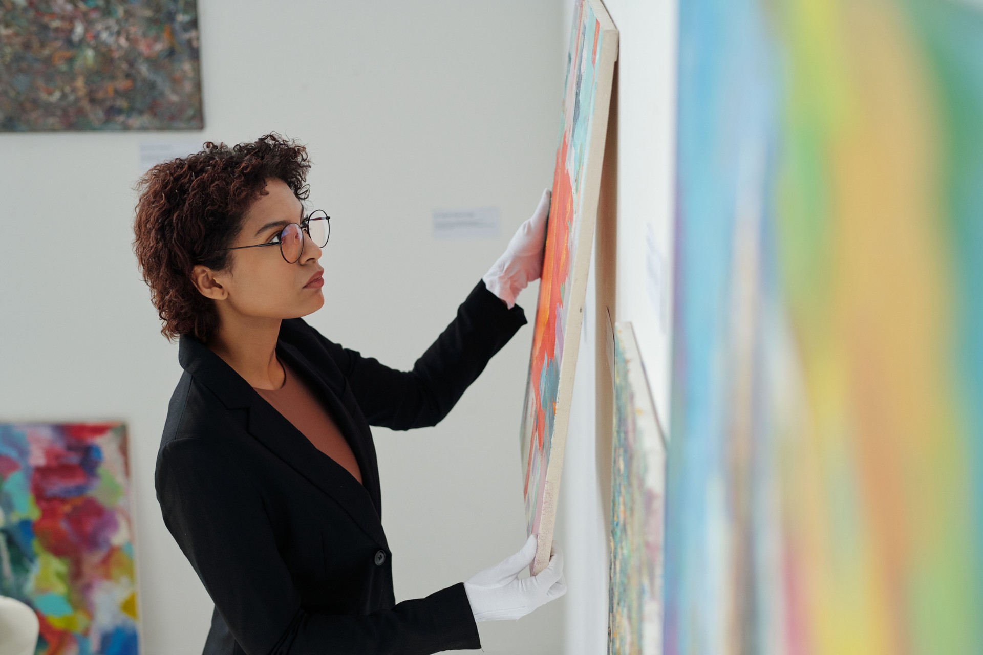 Gallery owner hanging paintings on the wall